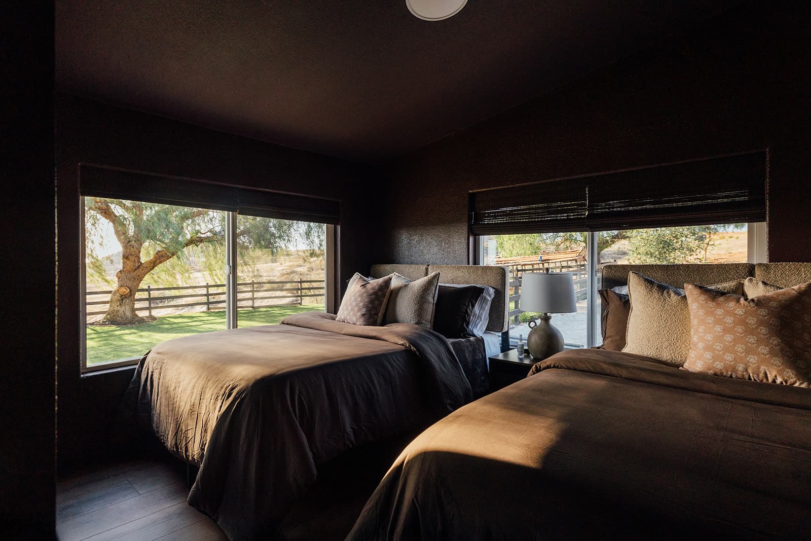 Bedroom with two queen beds framed by willow-tree views