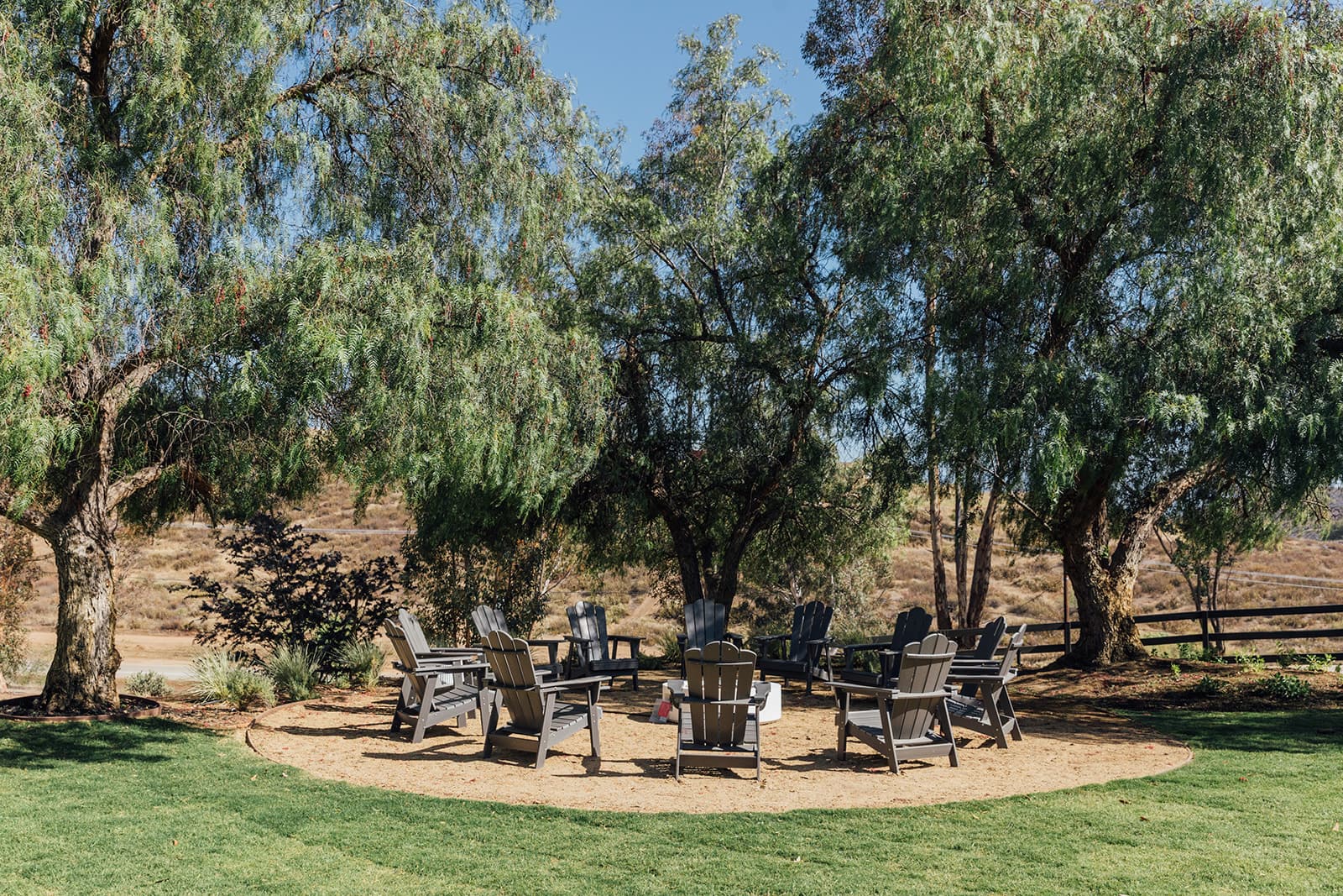 Fire pit ringed with Adirondack chairs