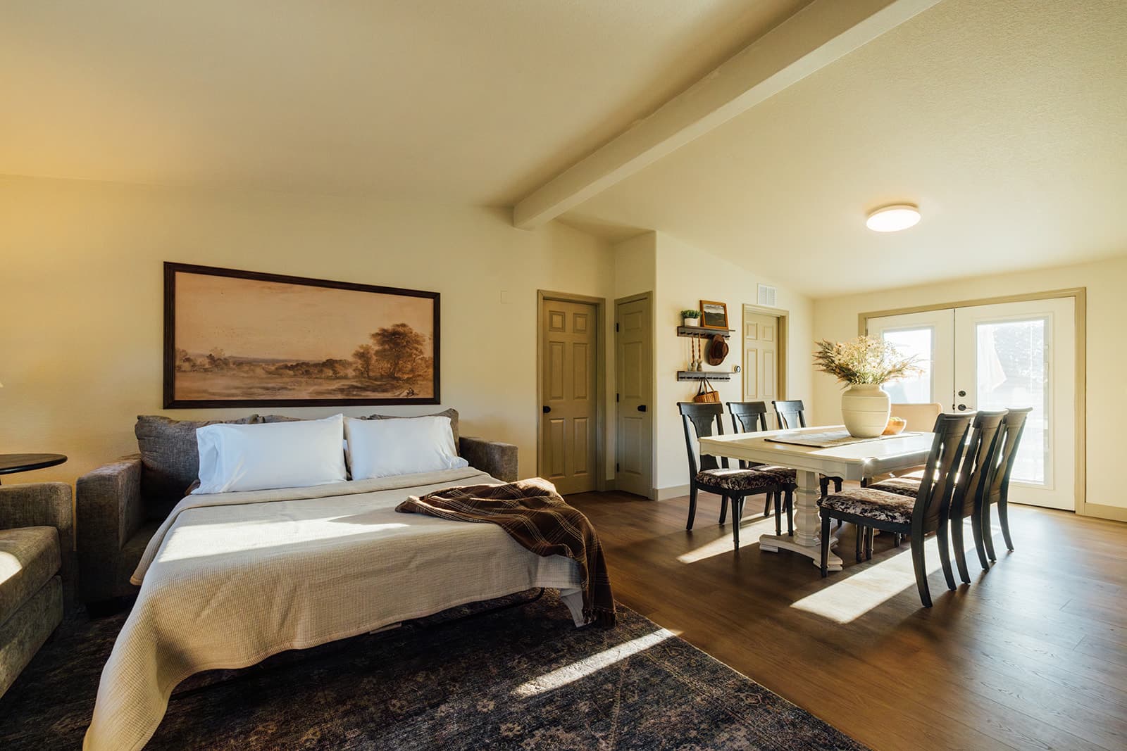 Open great room with a queen sleeper sofa beside the dining table