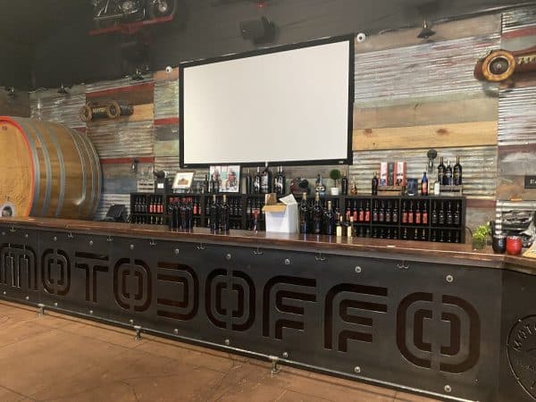 MotoDoffo tasting bar at Doffo Winery with wine barrels and reclaimed wood