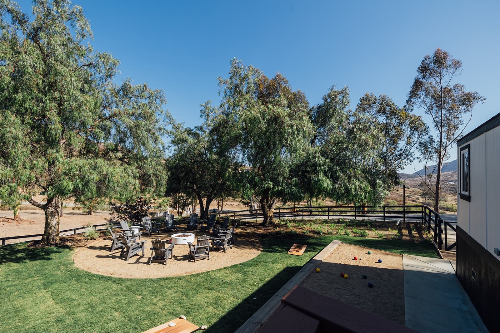 Private backyard on eighteen acres — fire pit, lawn games, and hill views